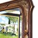 Italian sculpted mirror, patinated brown and gold wood, architectural frame from the 1960s.