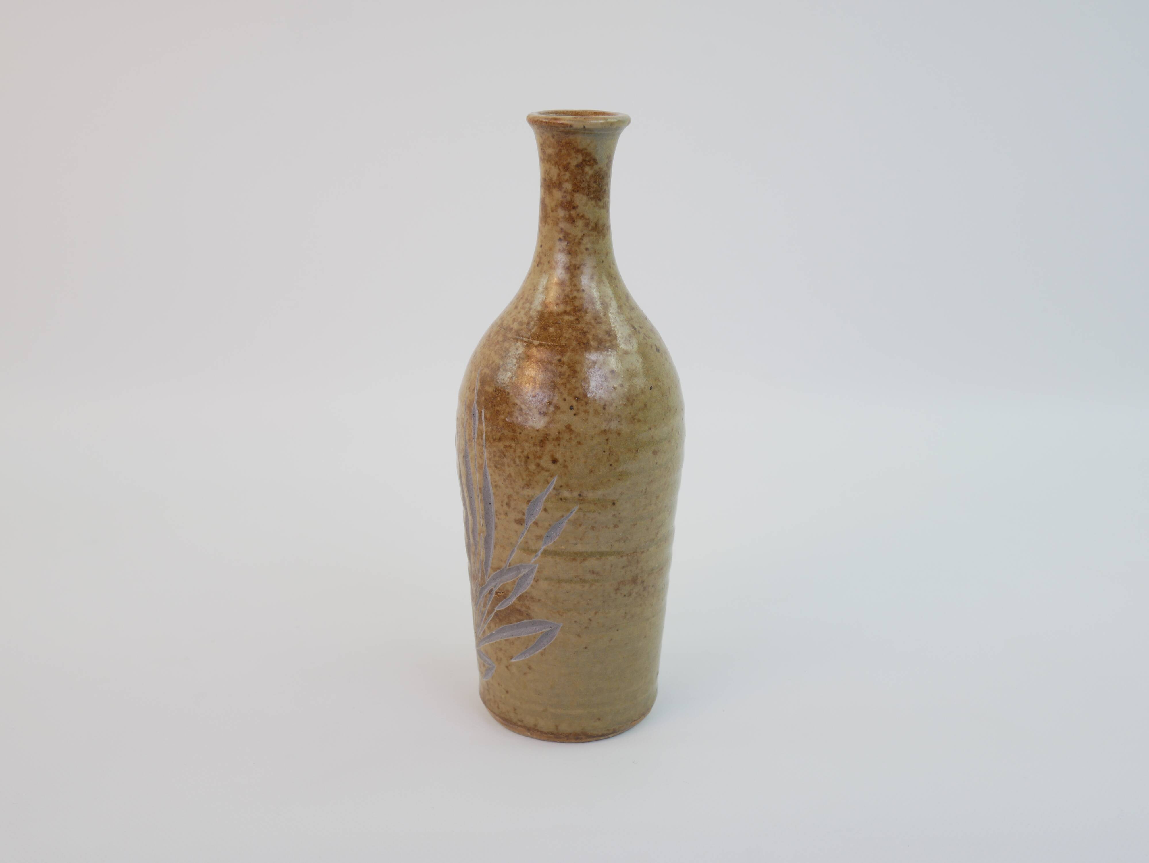Brown ceramic/stoneware bottle with chiseled floral pattern