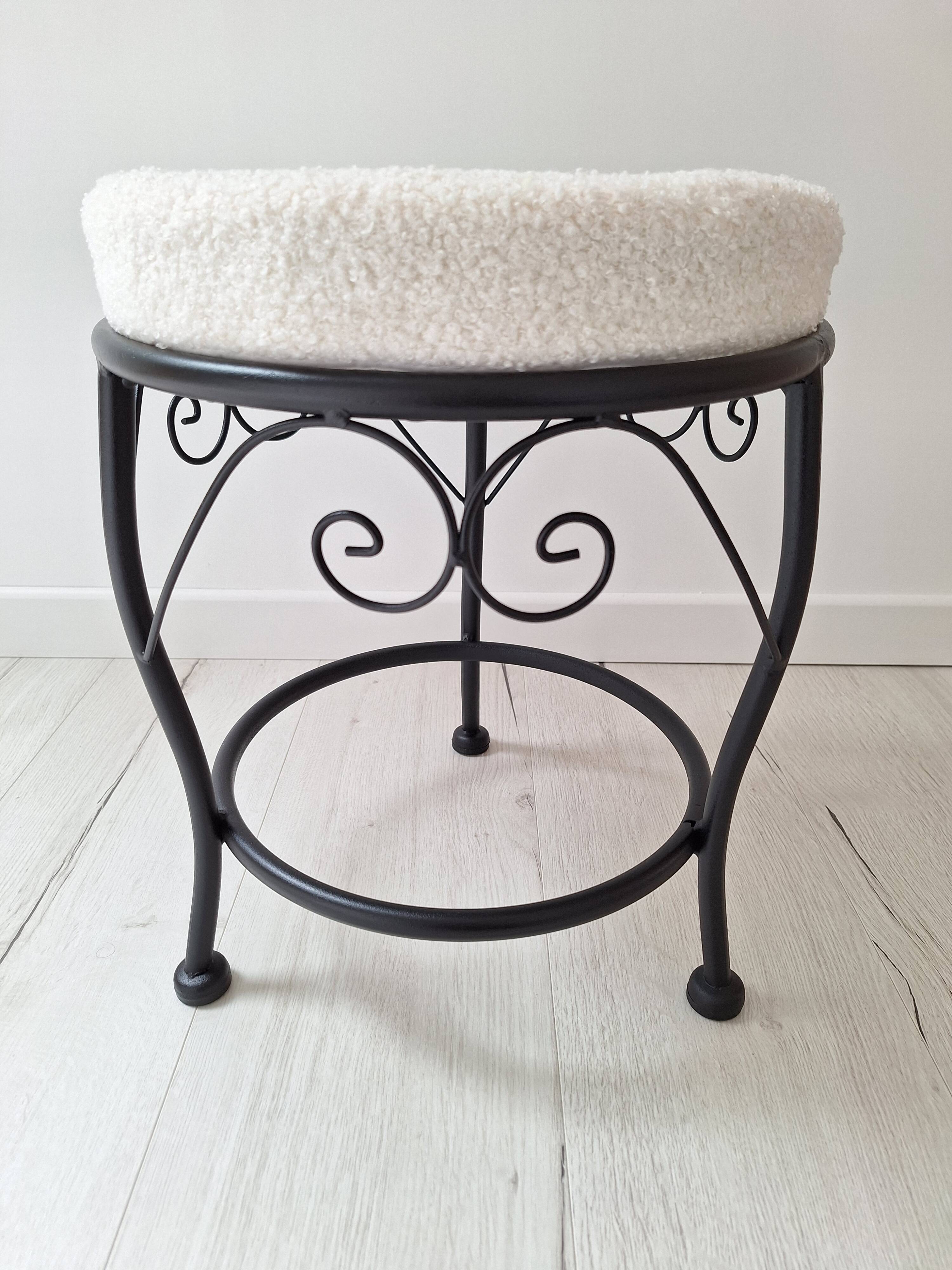 Black iron stool/pouf with its boucle fabric cushion.