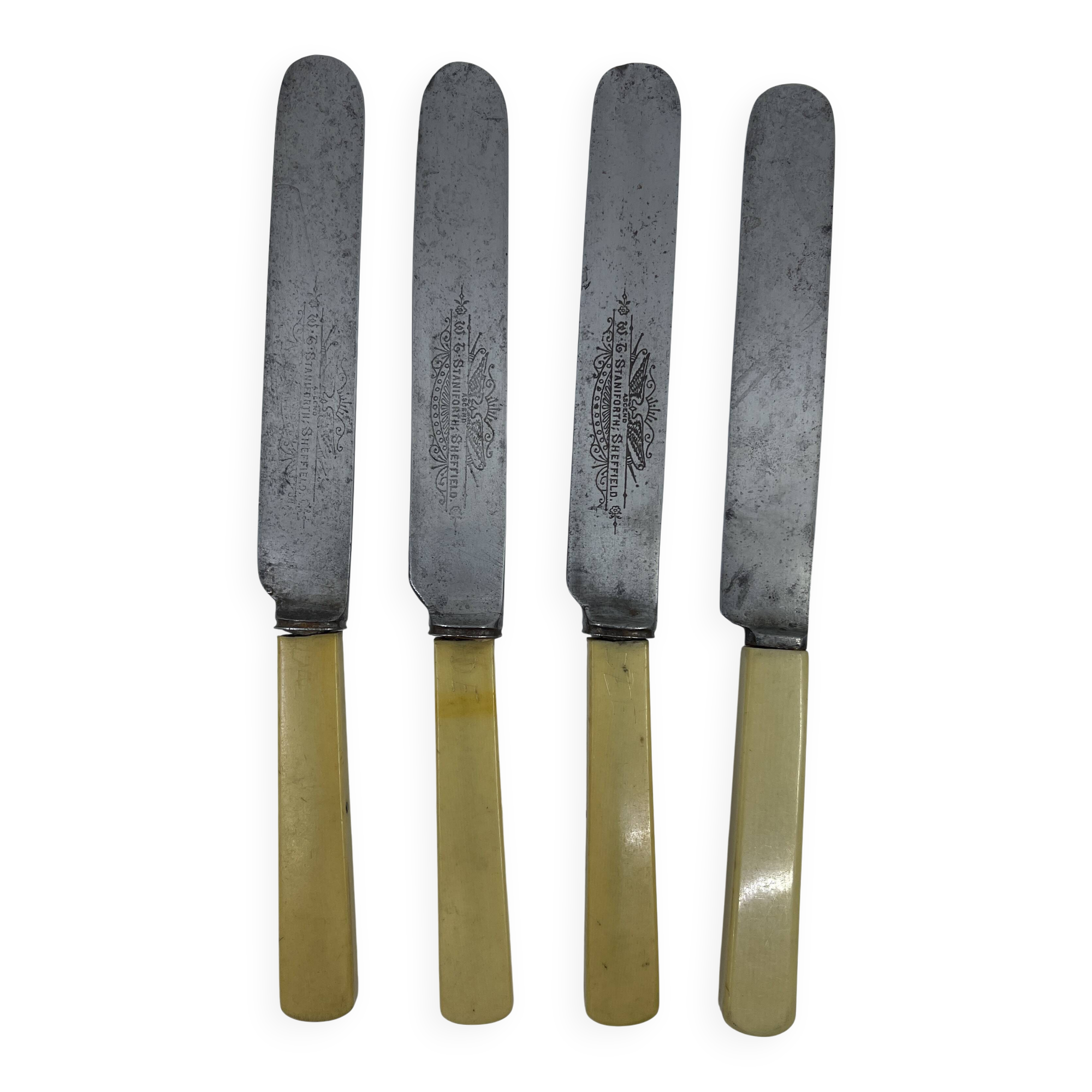 Set of 4 dessert knives with rounded tips and smooth ivory resin handles.