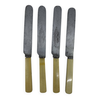 Set of 4 dessert knives with rounded tips and smooth ivory resin handles.