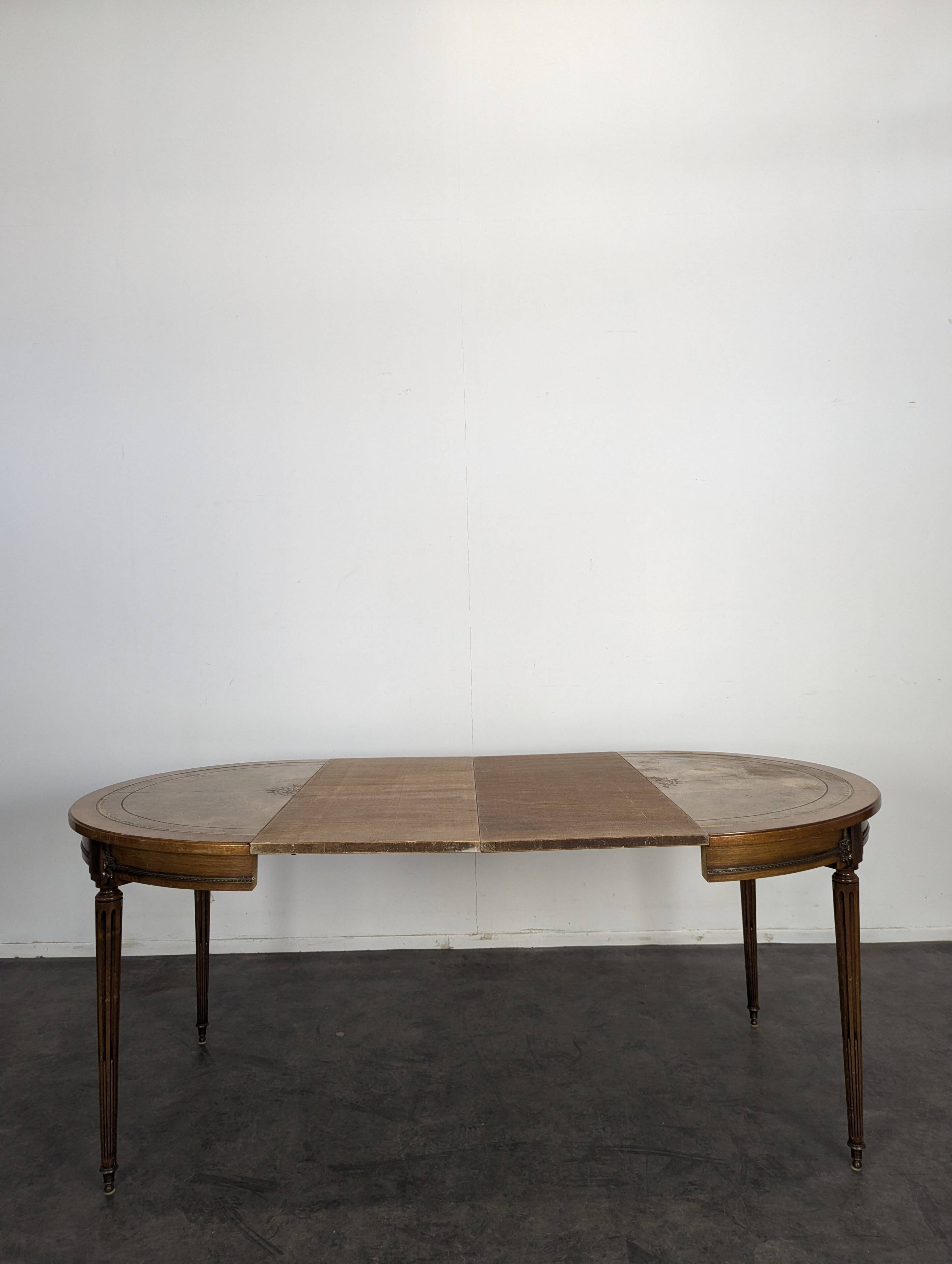Louis XVI style dining table with a leather top.