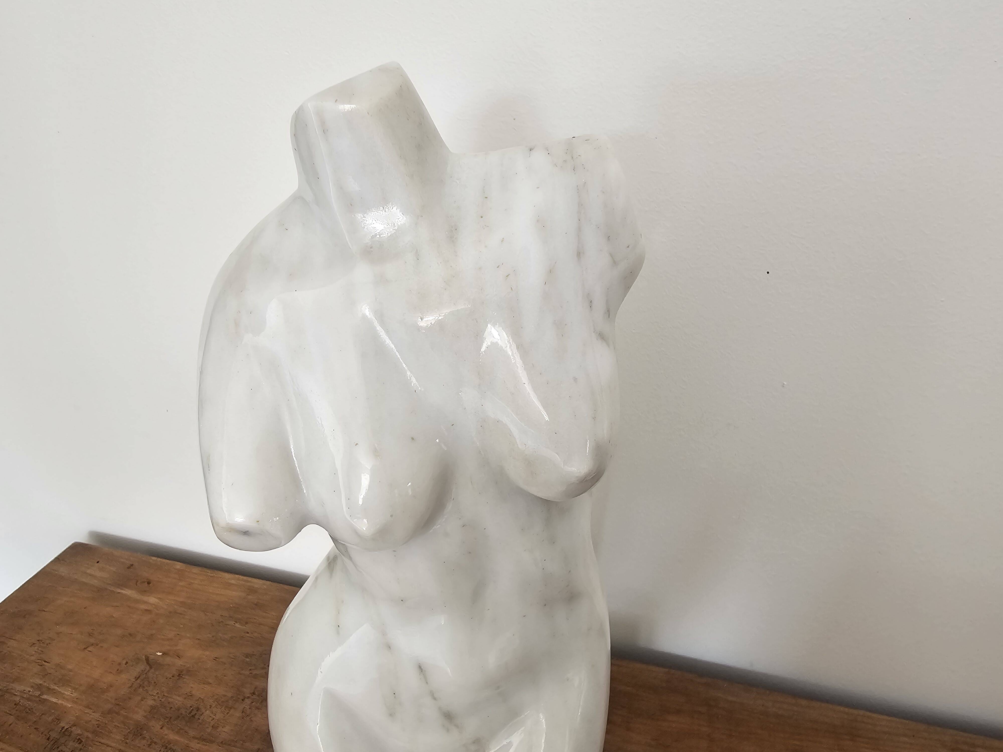 Sculpture of a female torso in white marble.