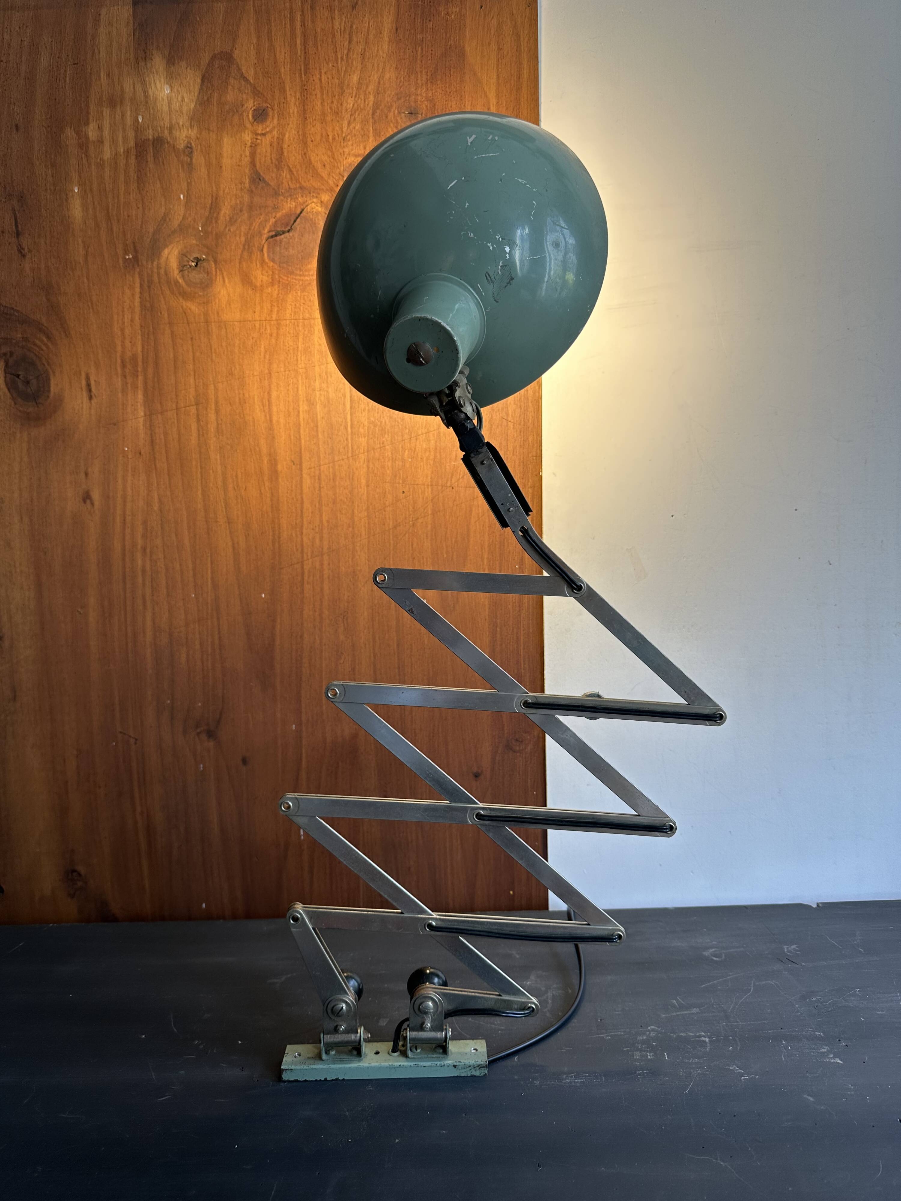 Old extendable accordion lamp in celadon green, workshop spirit.