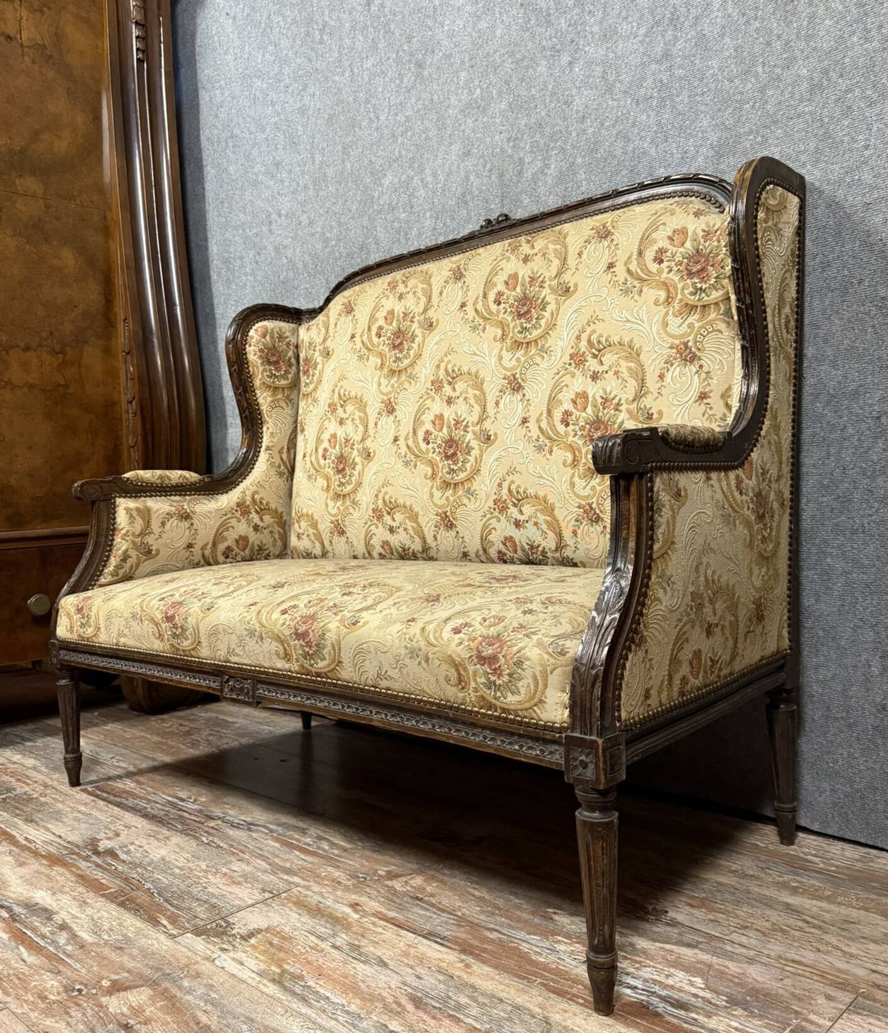 Banquette à oreilles de style Louis XVI en bois sculpté vers 1850