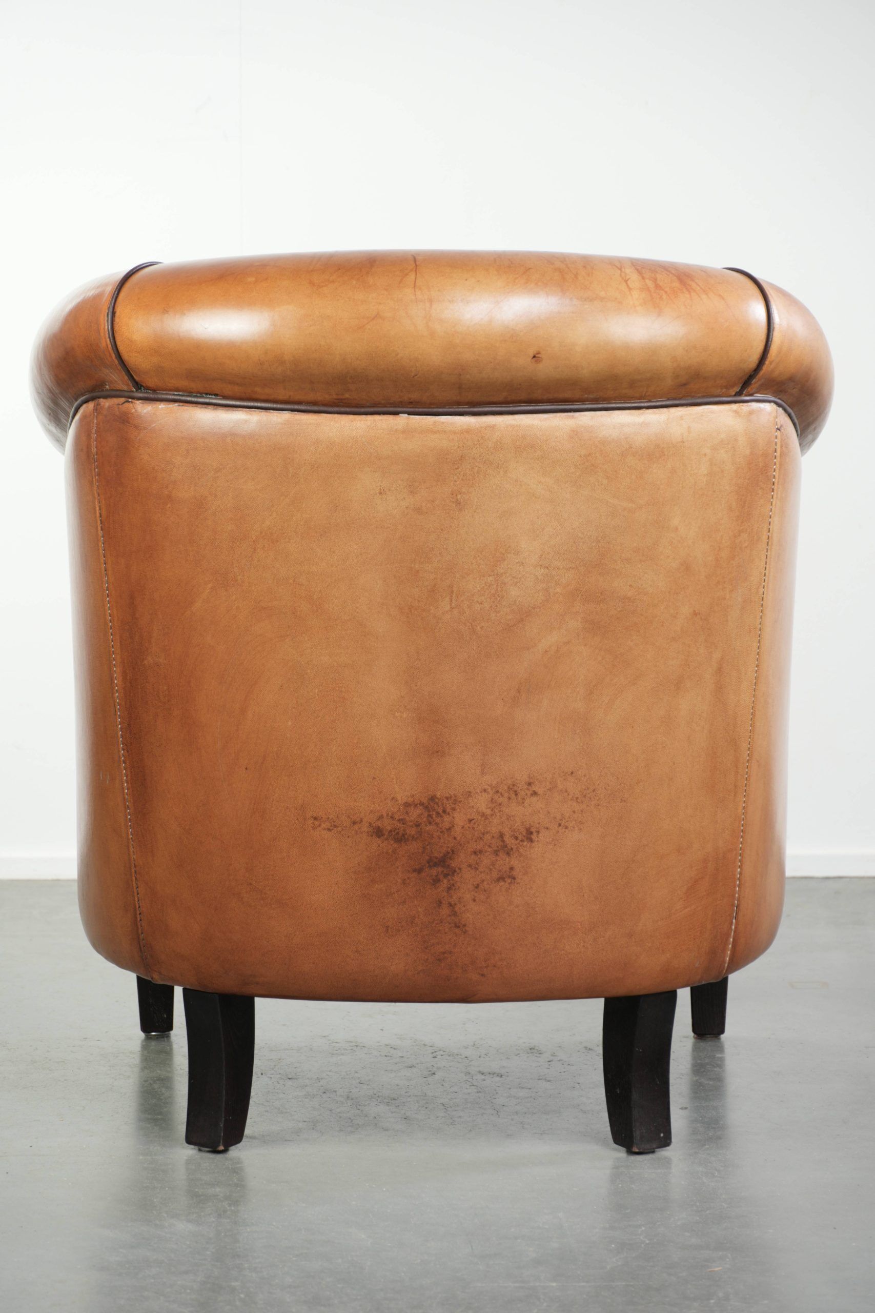 Vintage sheepskin club armchair with a warm colour scheme with black piping