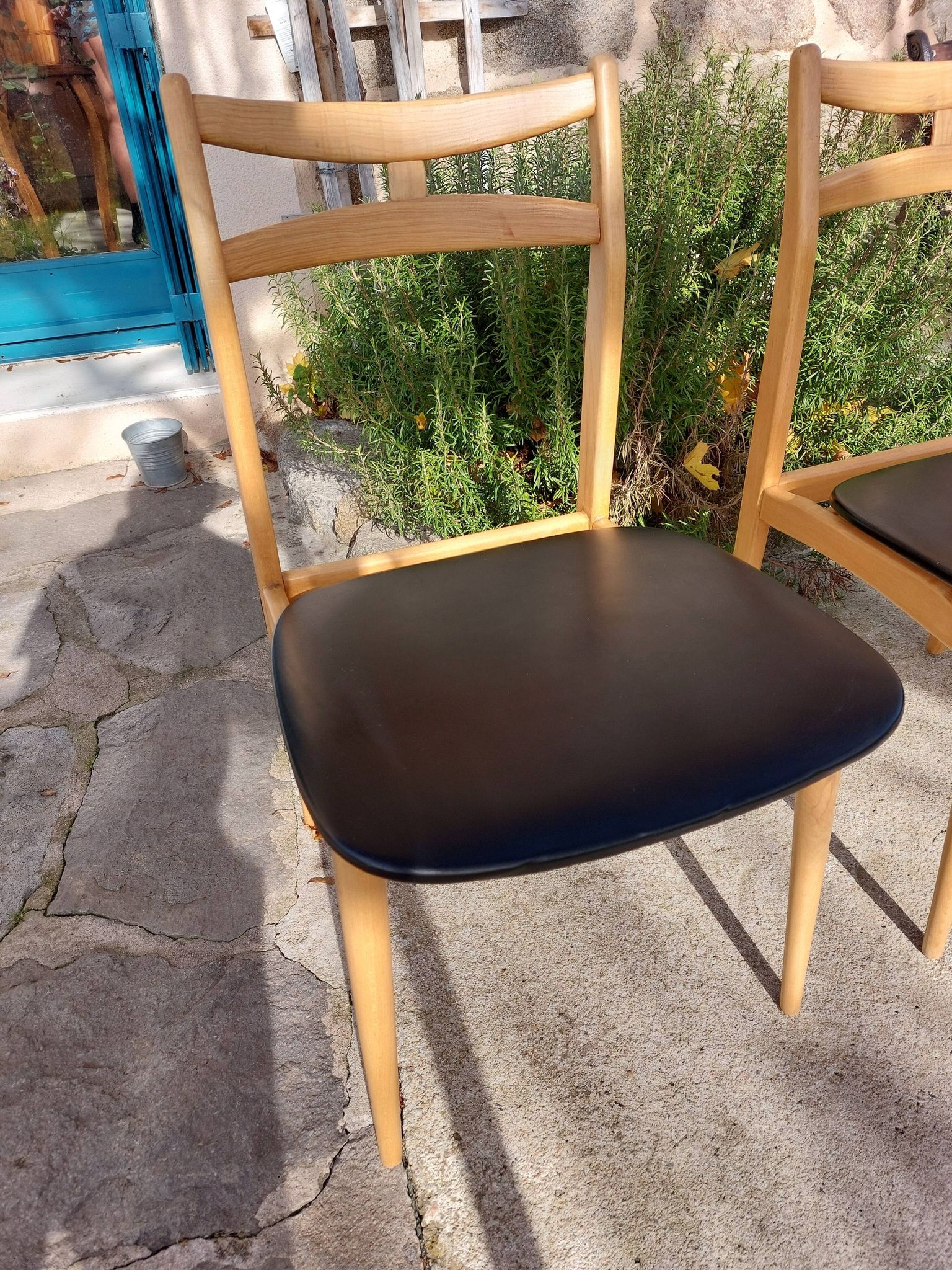 3 Scandinavian style chairs, light wood and black faux leather.
