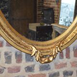 Golden oval mirror with a bow and a flower crown