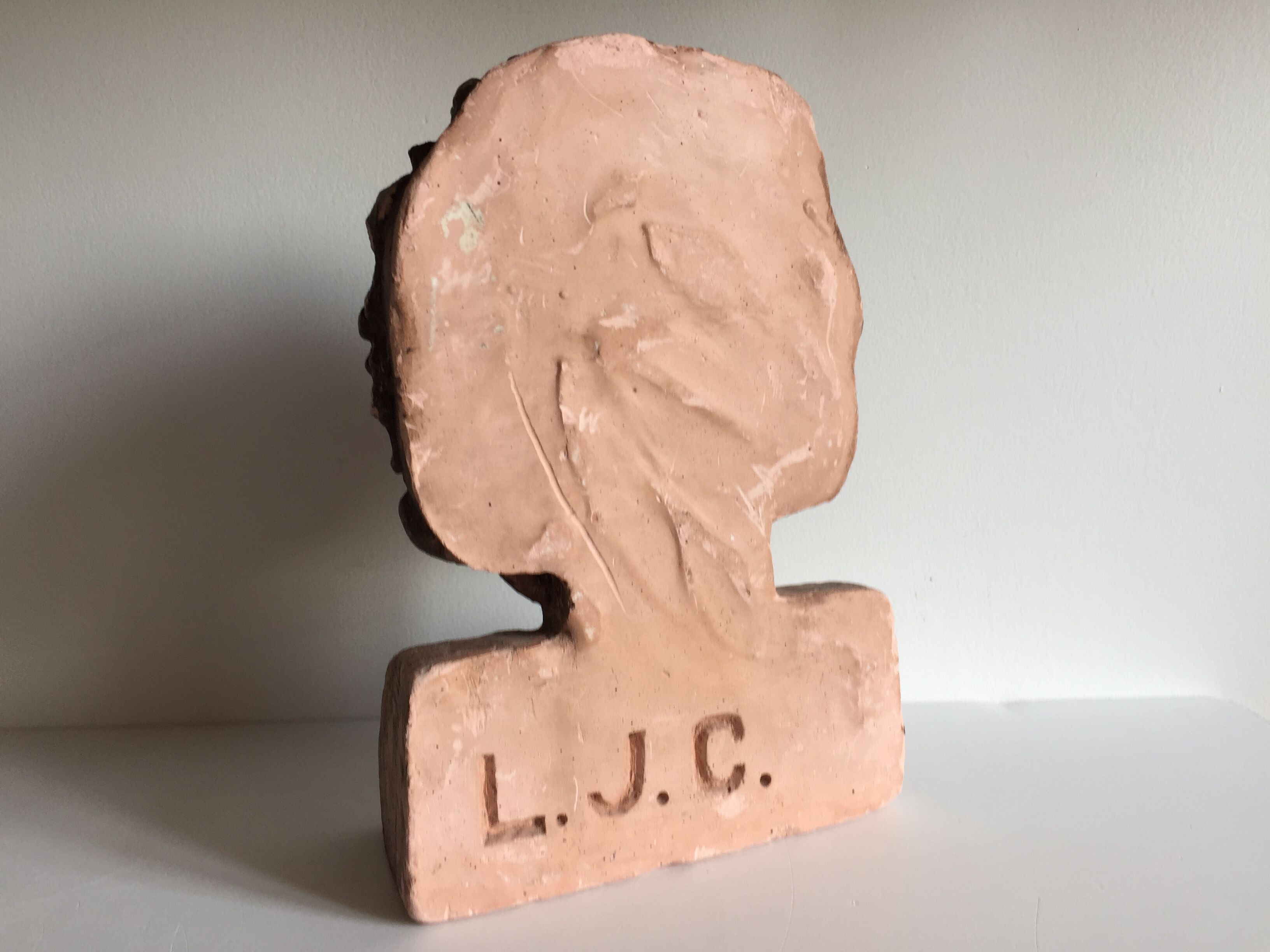 Bust old child in plaster stamped l.j.c.