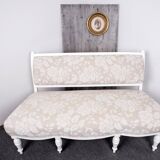 Two-seater canapé painted white with reupholstered beige fabric, wooden frame painted in 1890 style.