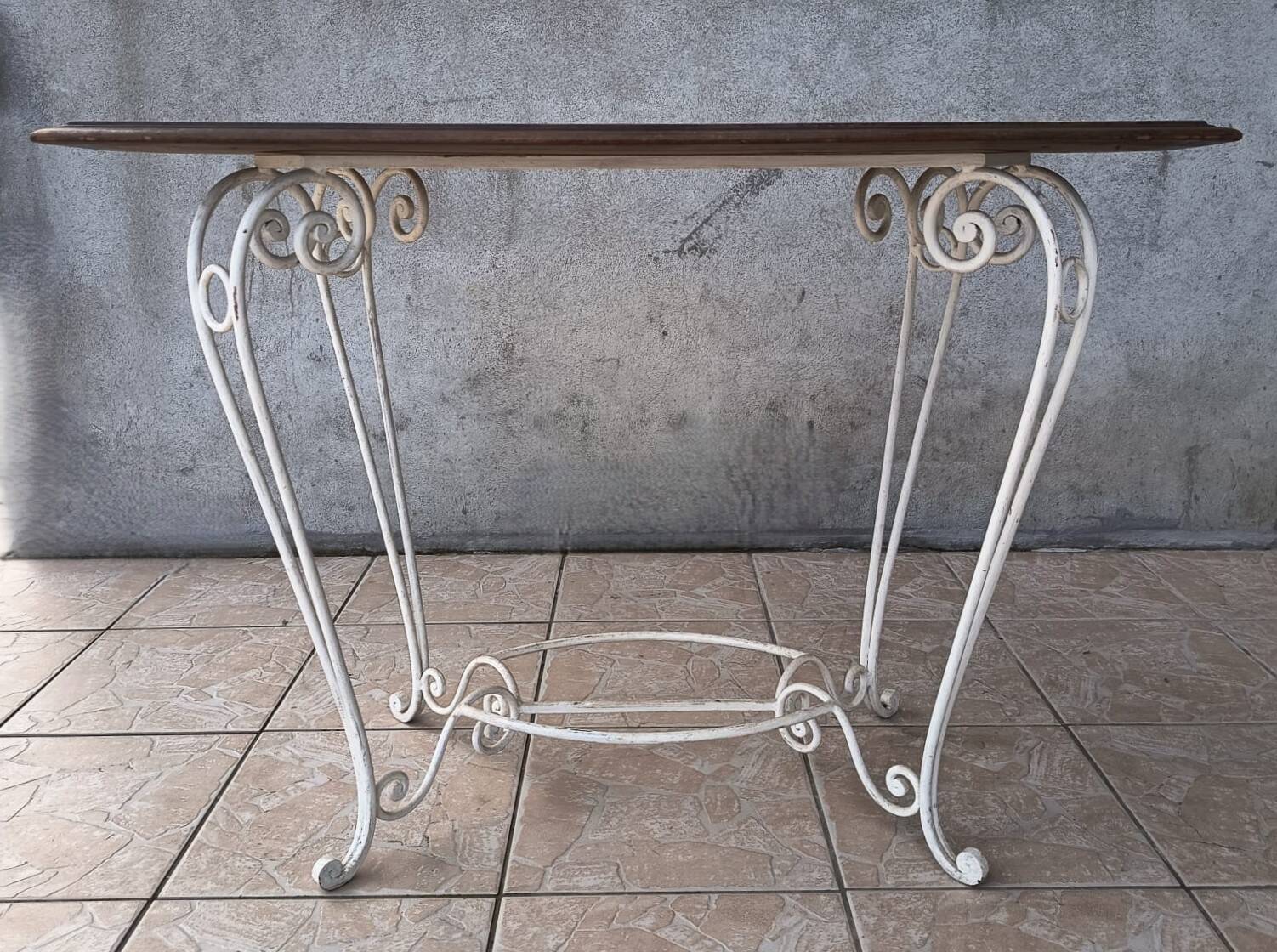 Wrought iron table with a walnut top.
