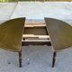 Extendable round table in solid wood with a dark oak satin finish.