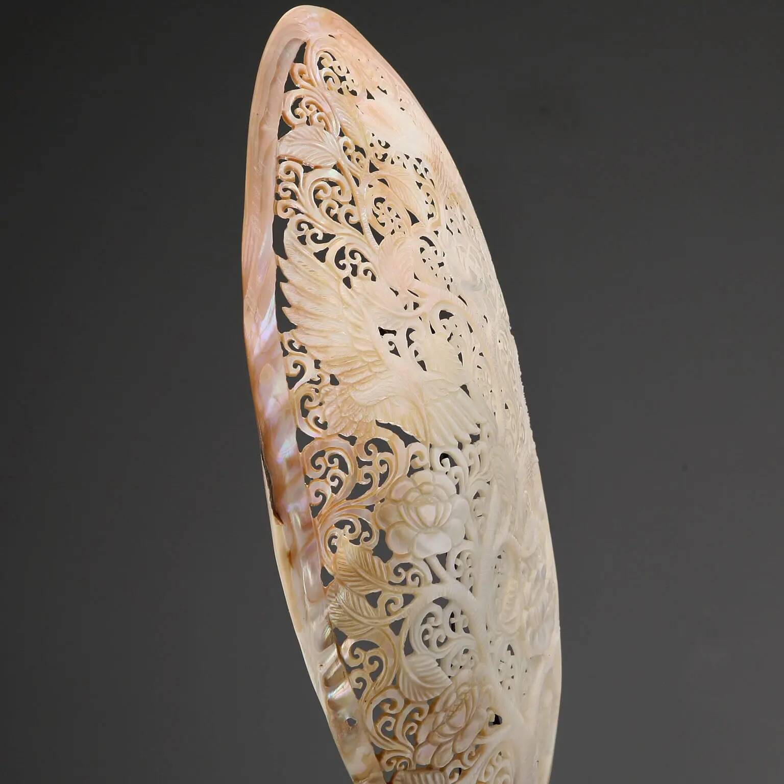 Perforated shell hand-decorated on a wooden base