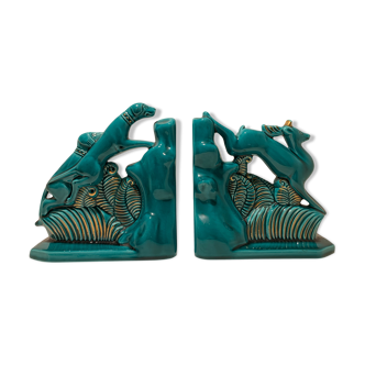 Pair of art deco bookends in enamelled ceramics, doe and hunting dogs