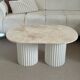 Oval coffee table in travertine and white fluted wood.