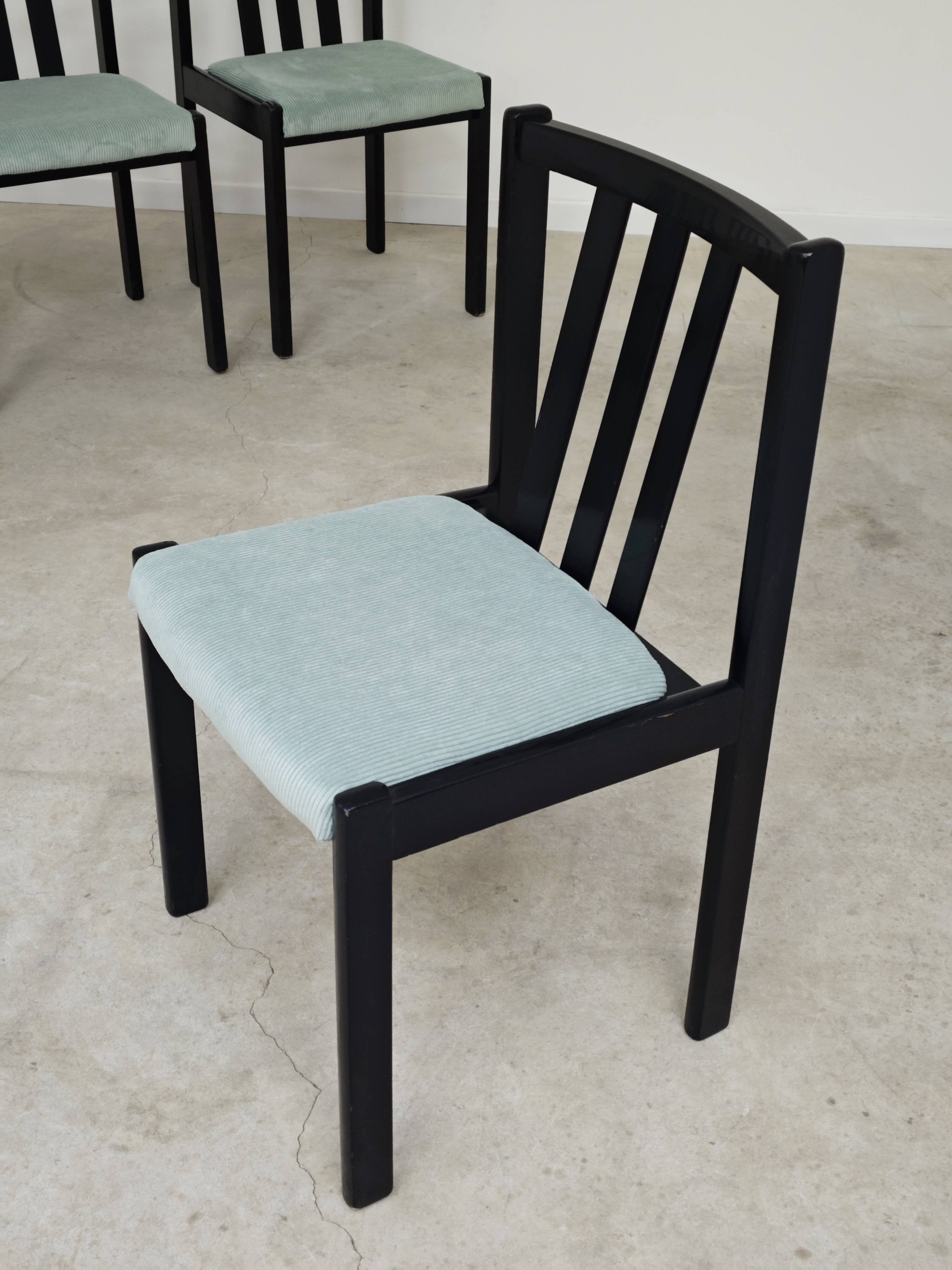 Set of 6 modernist black chairs with light blue-green ribbed fabric.