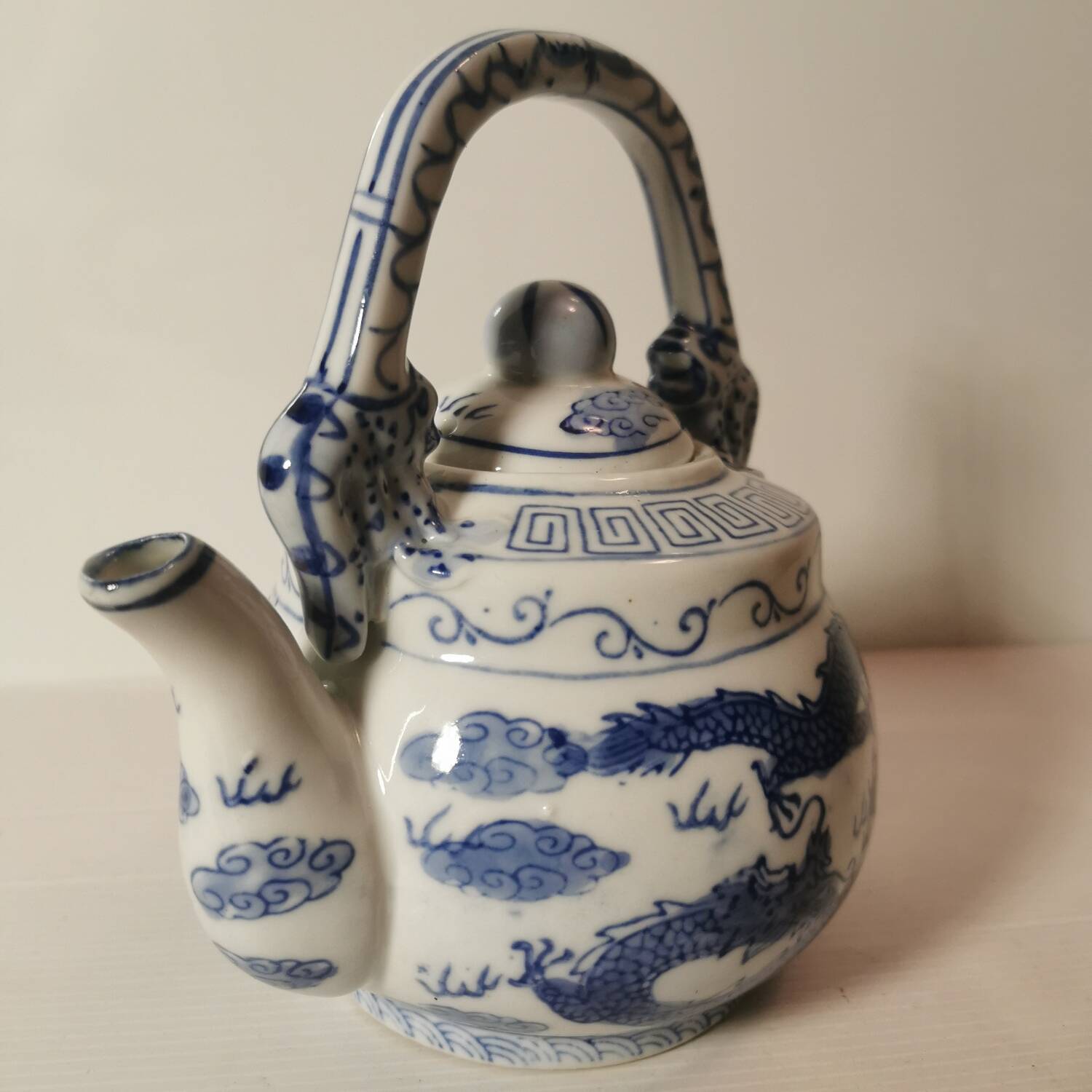 Old Chinese blue and white teapot in vintage ceramic with dragon decor