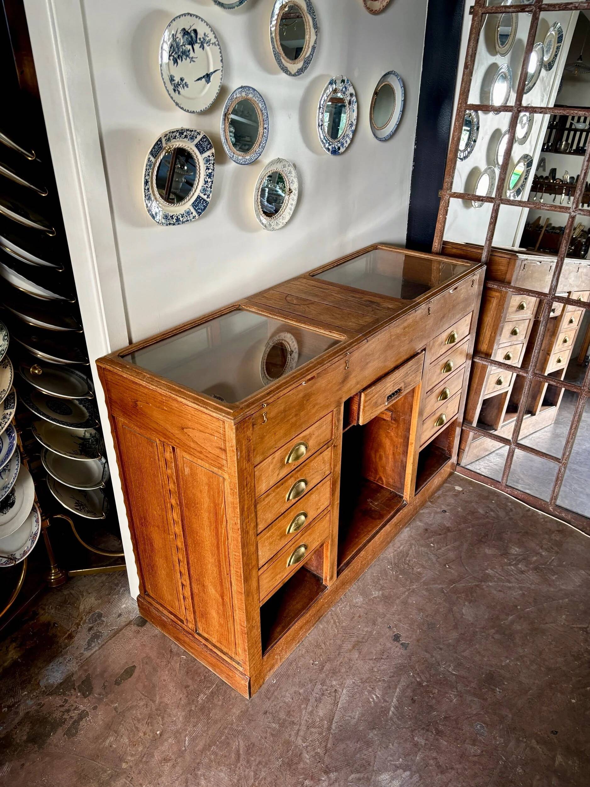 Counter, glass-fronted wooden workbench in dark wood, 8 drawers.