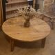 Large round antique coffee table made of raw solid wood.