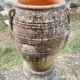 Large Cretan jar in terracotta with three handles on a stone base.
