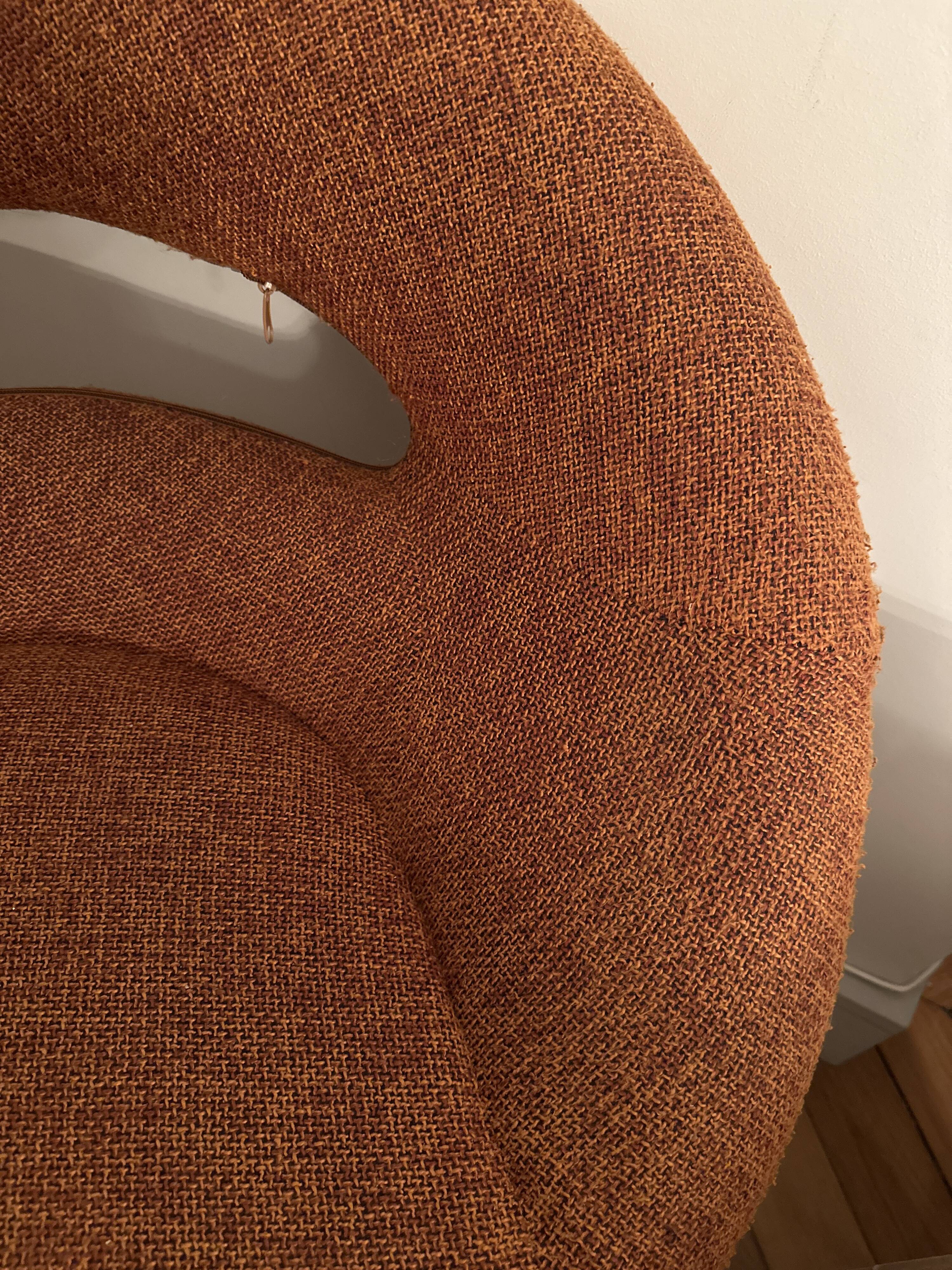 Circular armchair trimmed with orange fabric