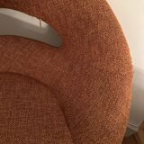 Circular armchair trimmed with orange fabric