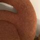 Circular armchair trimmed with orange fabric