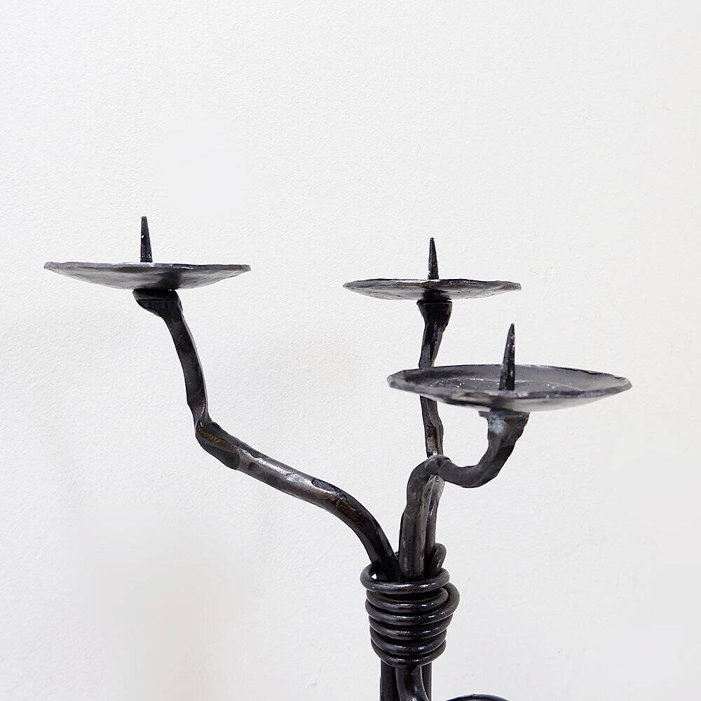 Large wrought iron candelabrum with an abstract design and three candle holders.