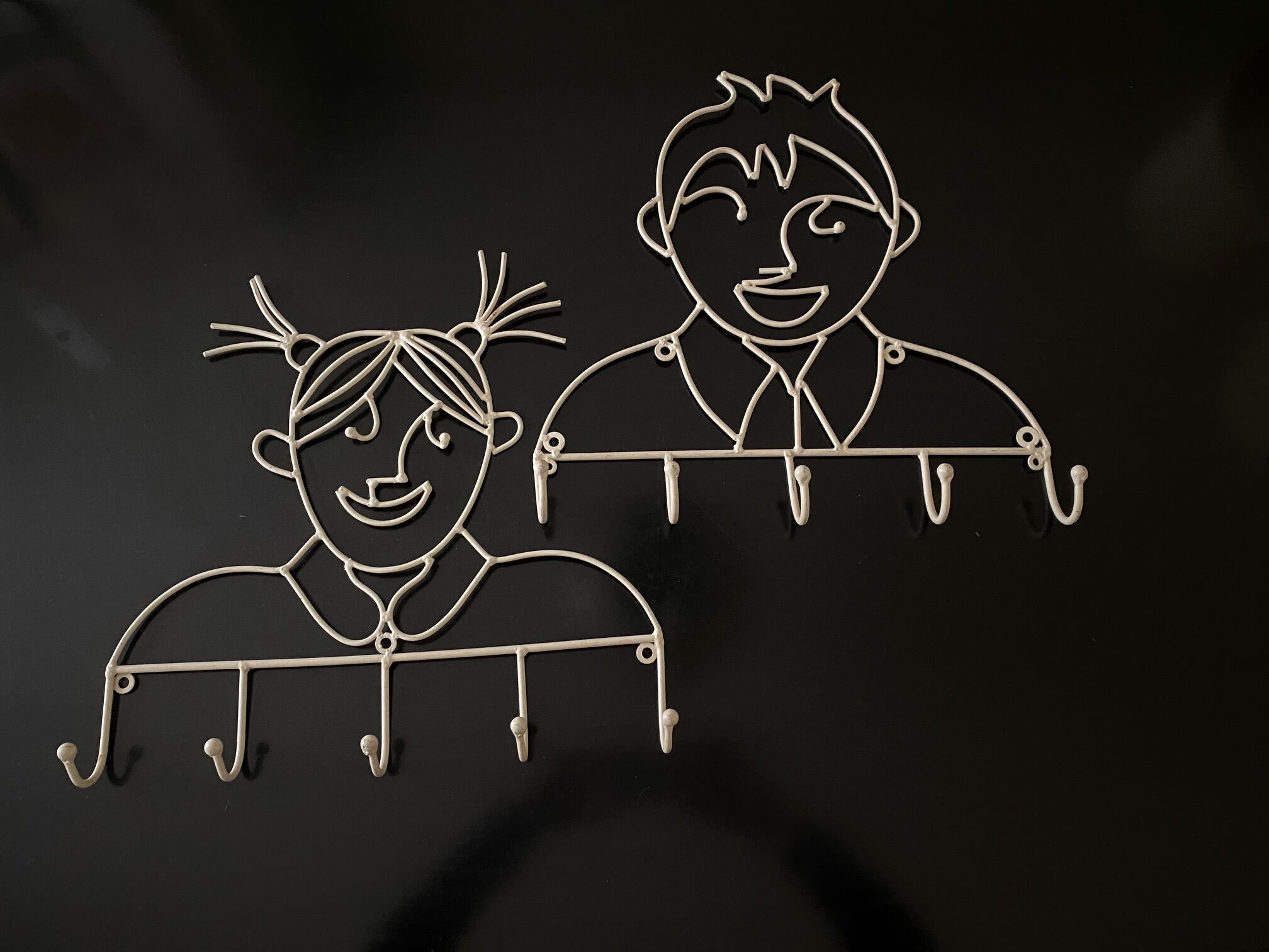Pair of iron coat holders girl and boy