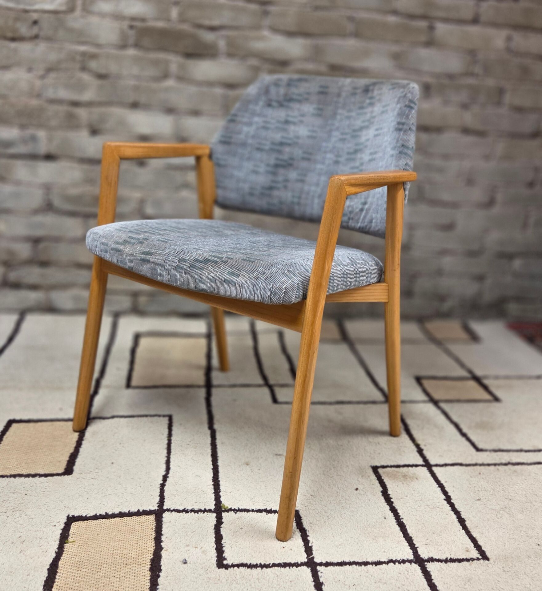 Vintage armchair from the 60s/70s in wood and grey fabric – with armrests.