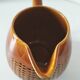 Caramel slipware pitcher with braided relief