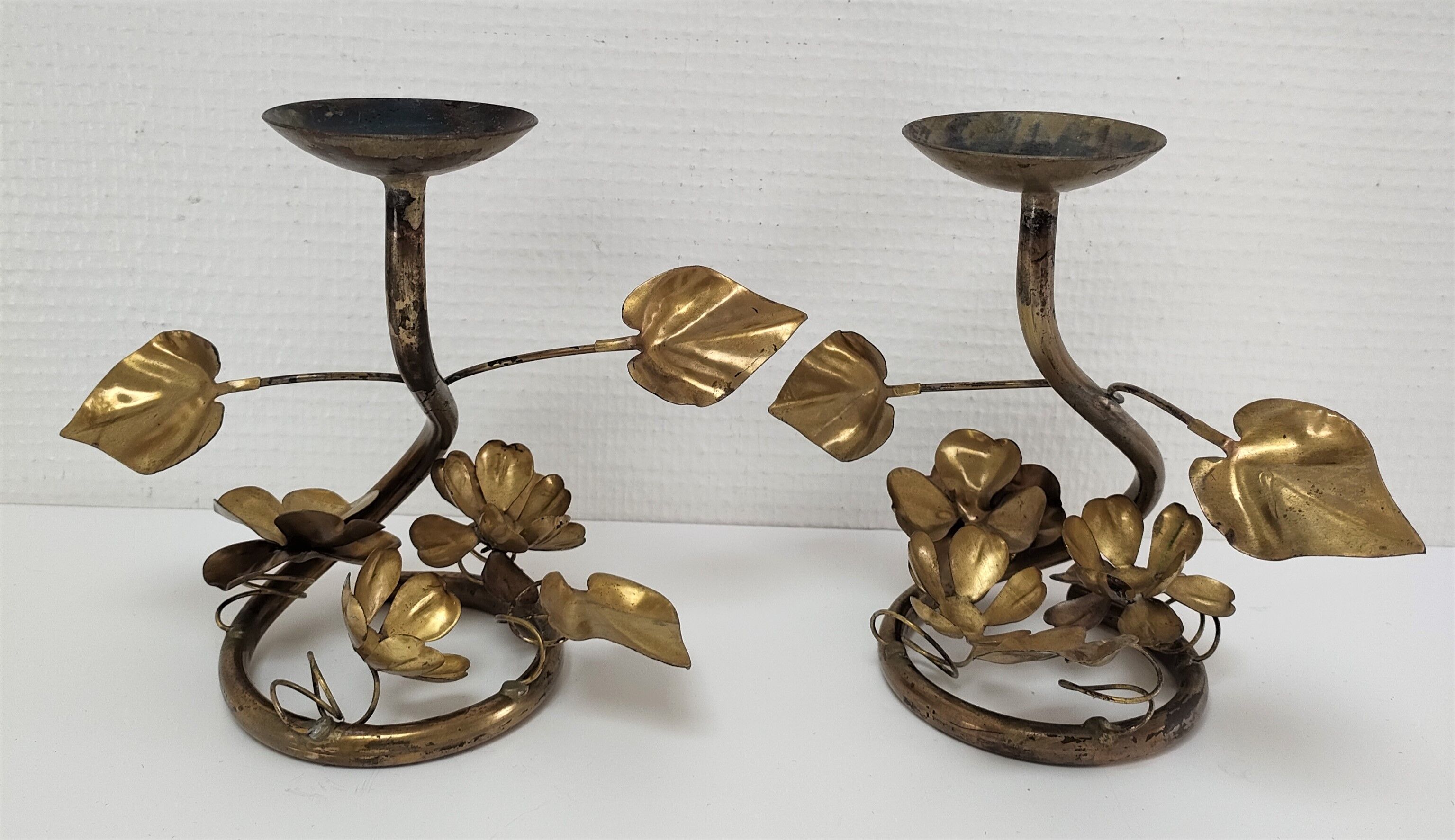 Pair of brass candle holders decorated with patinated metal flowers