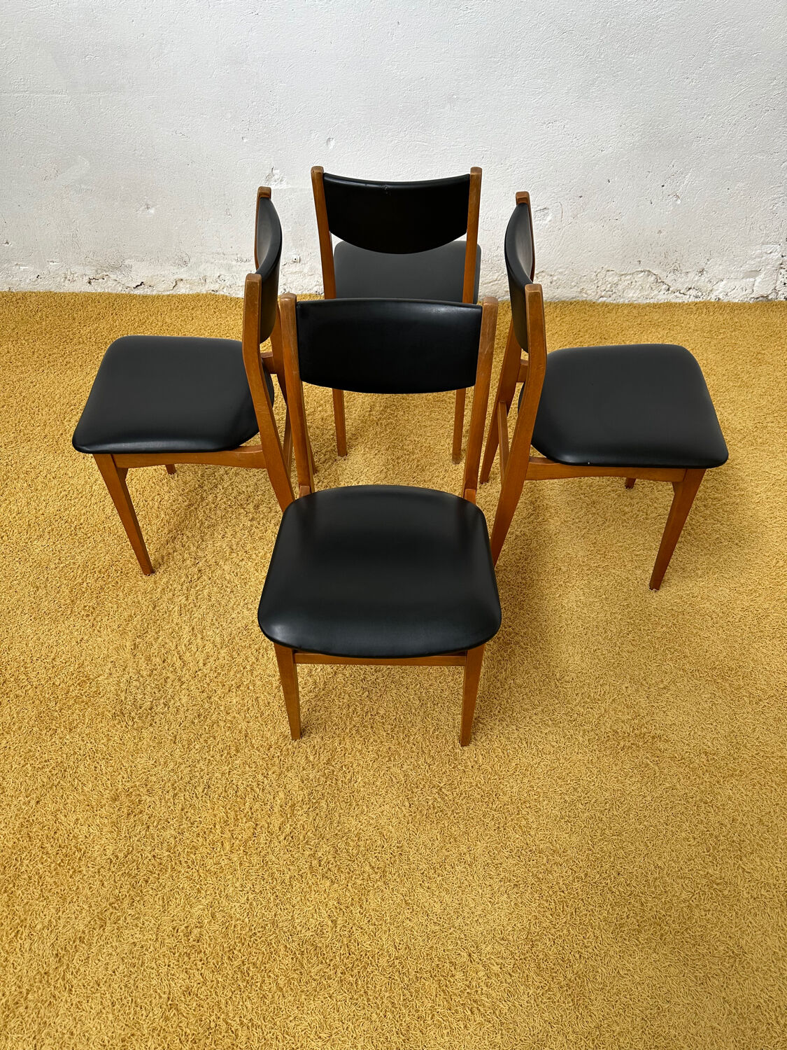 4 Scandinavian chairs in teak and black faux leather.