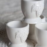 Vintage white porcelain egg cups with fruit motif.