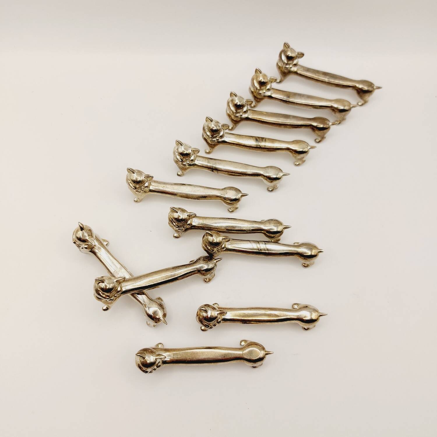 12 vintage silver metal cat knot knife rests