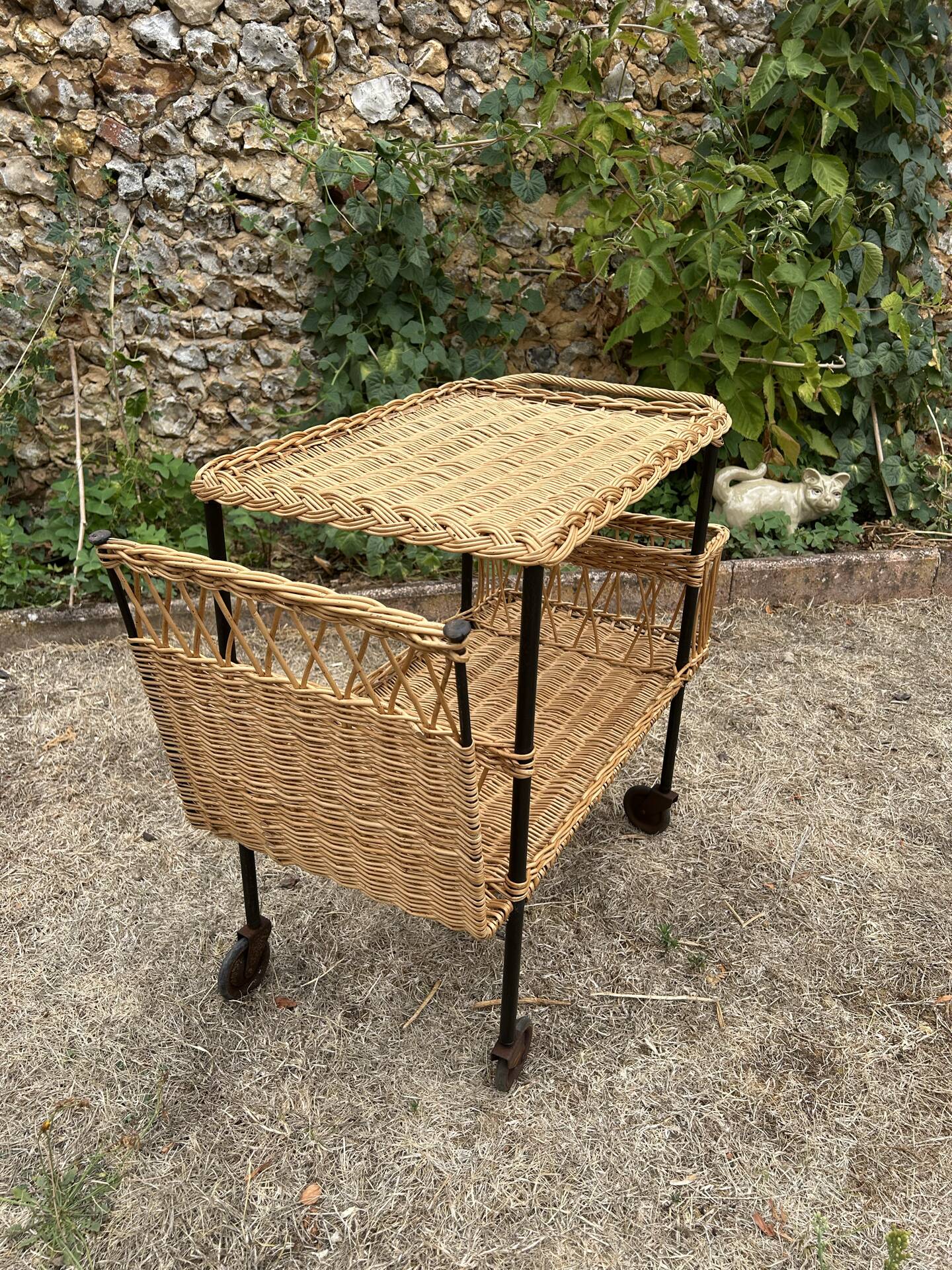 Vintage 1950s rolling dessert trolley in wicker and black tubing.