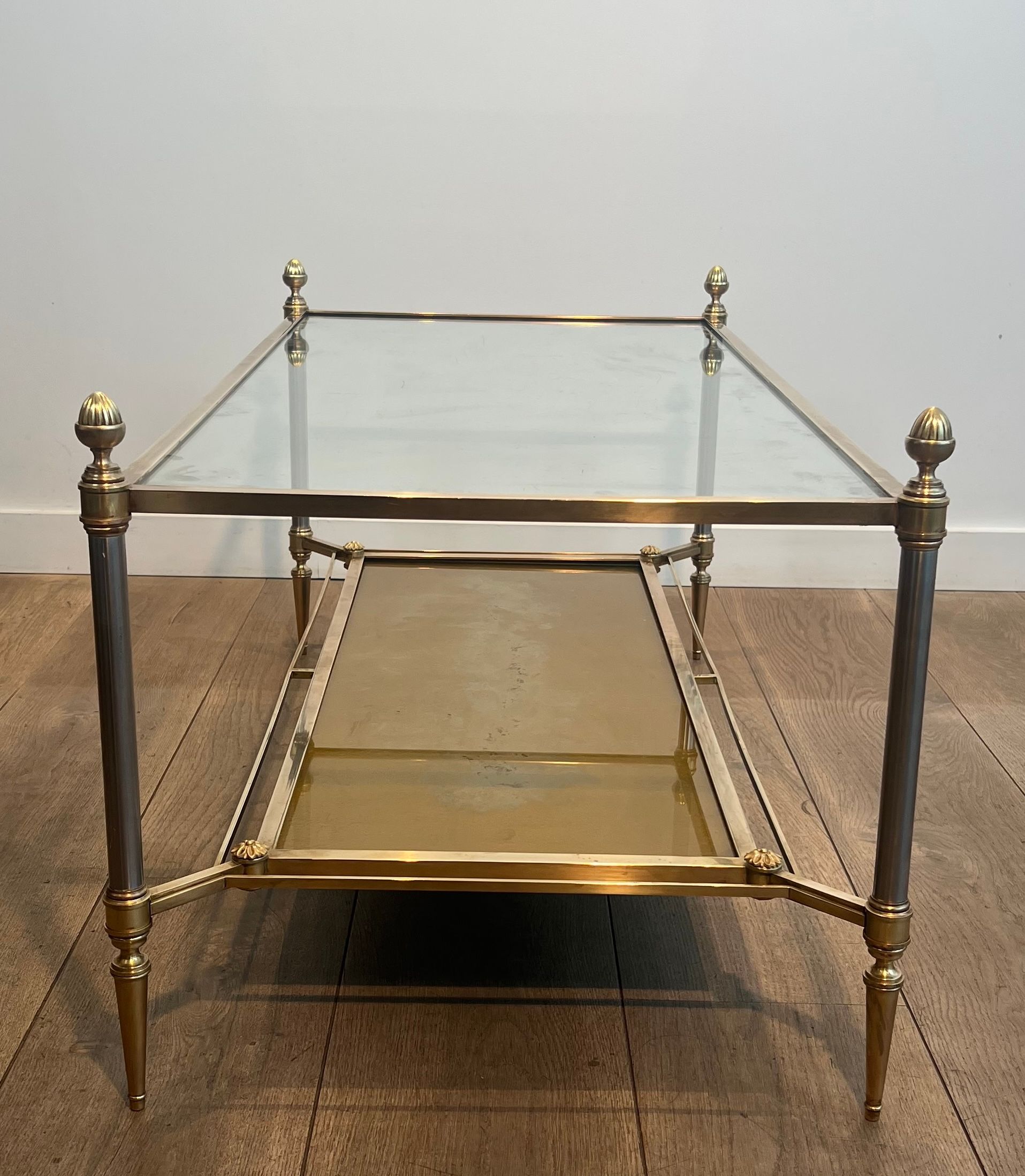 Coffee table in brass, brushed steel, glass, and gilded eglomisé mirror from Maison Jansen.