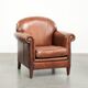 Sheepskin armchair with comfortable seat and finished with decorative nails