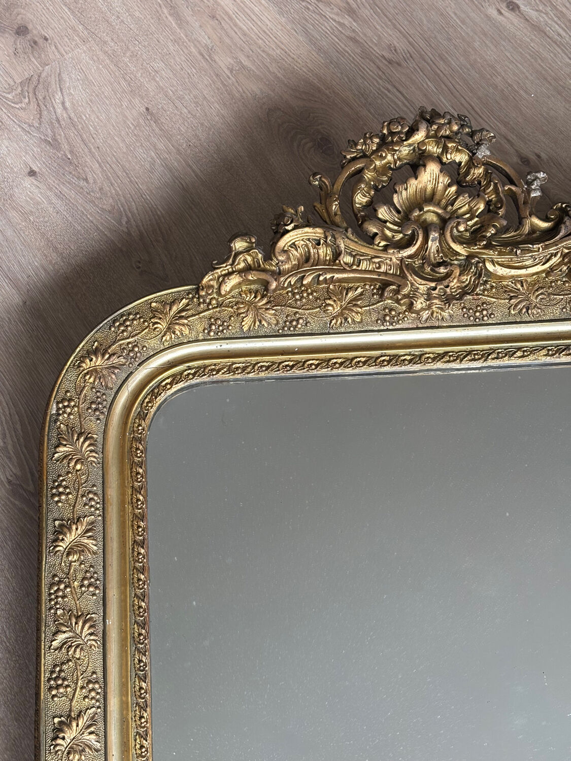 Golden mirror with a pediment from the early 20th century.