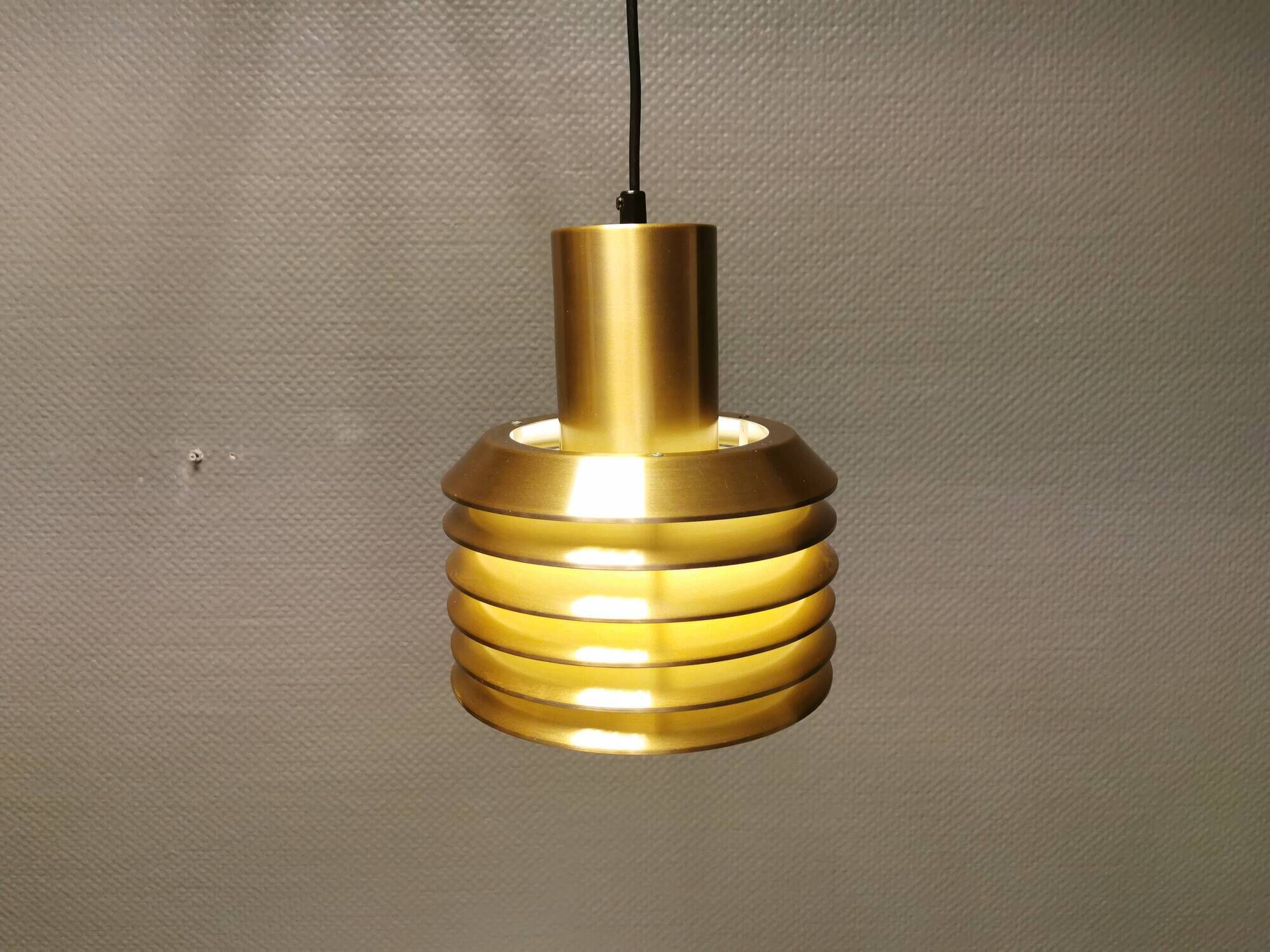 Hanging lamp in gold-colored aluminum with many layers of shades.