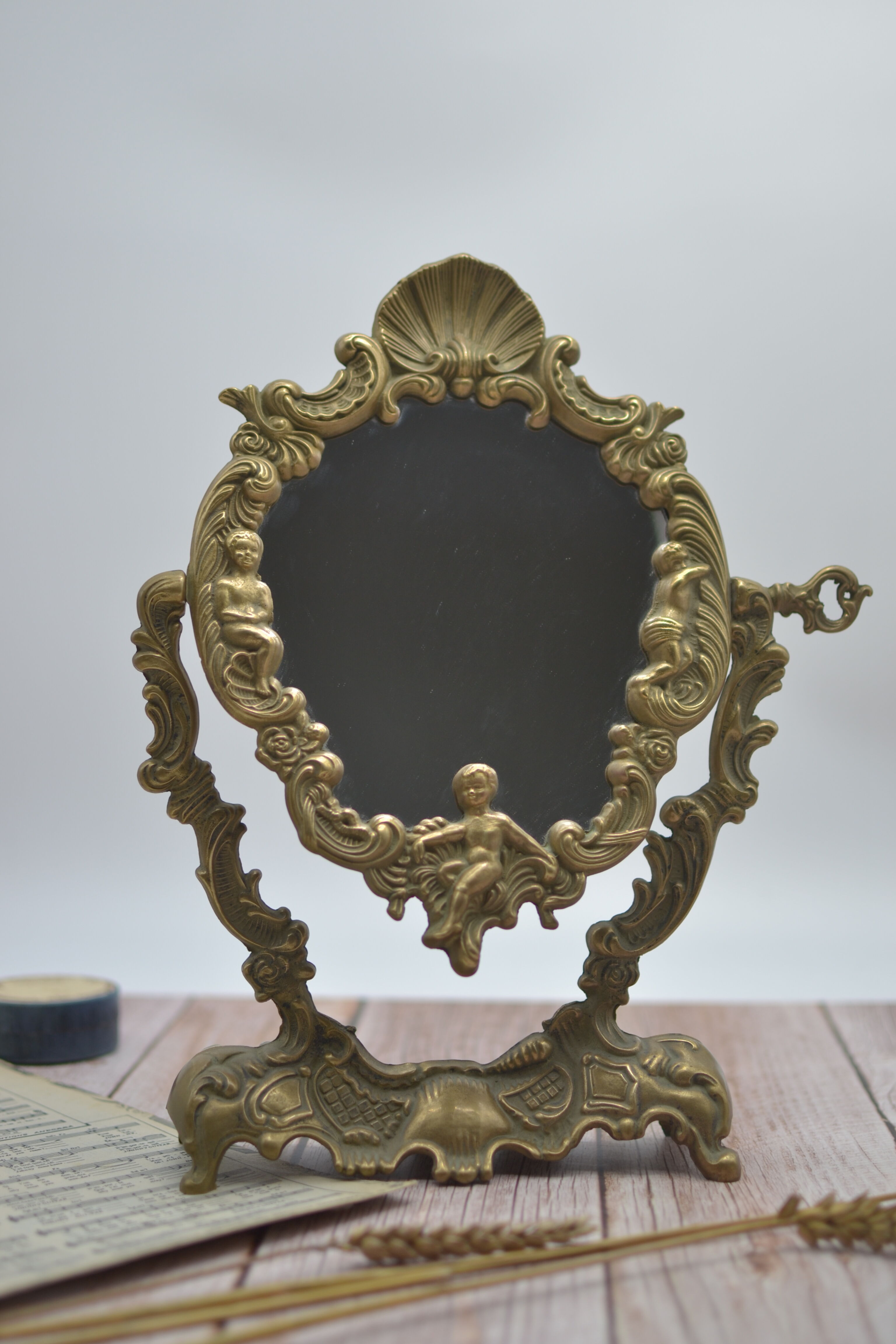 Adjustable psyche mirror of 33 centimeters in gilded bronze with angel ornament
