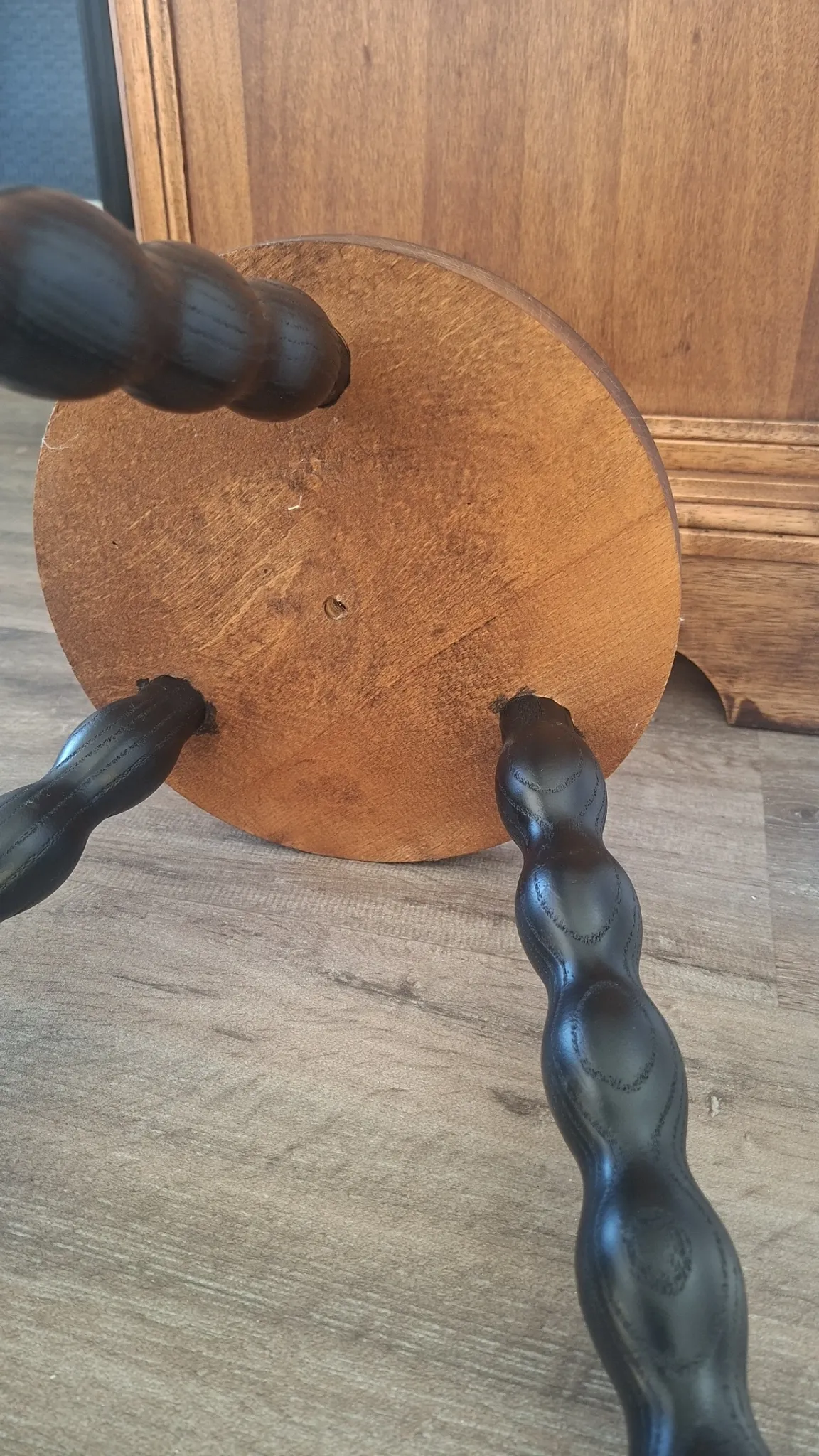 Brown and black wooden tripod stool