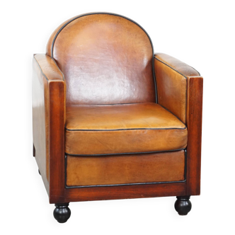 Fauteuil design Art Déco en cuir de mouton et bois avec pieds boule