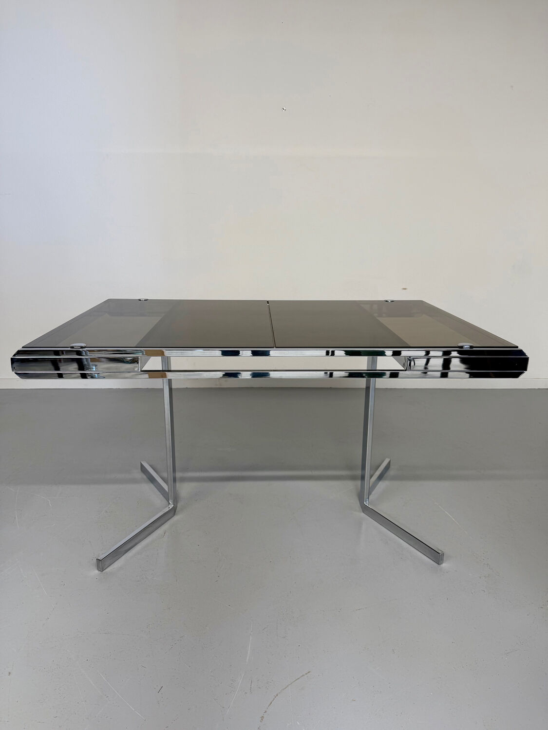 Smoked glass dining table with chrome legs, 1970s design by Roche Bobois.