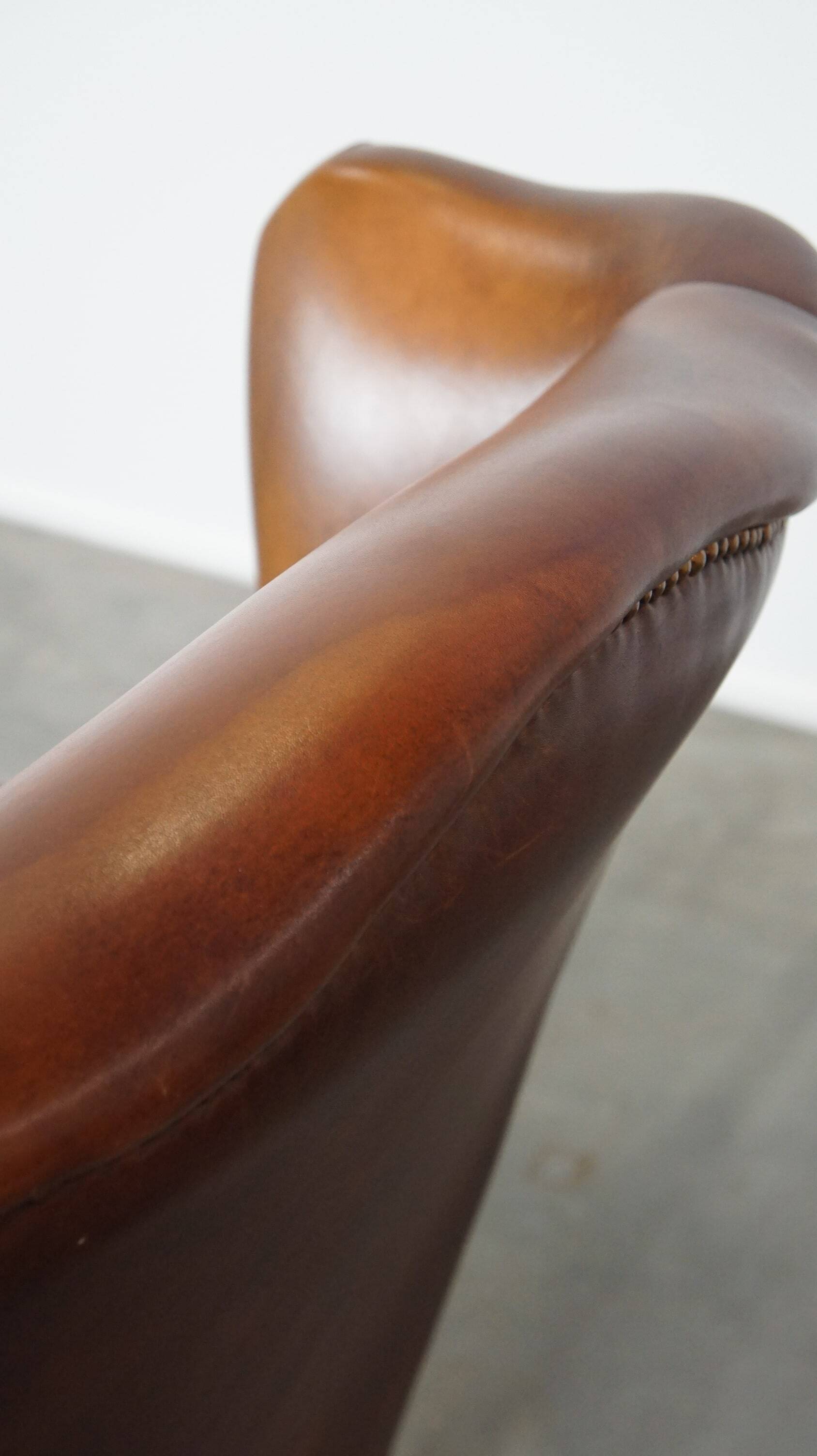 Fauteuil à oreilles en cuir de vachette cognac