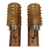 A set of wall lamps in teak wood, with amber colored glass