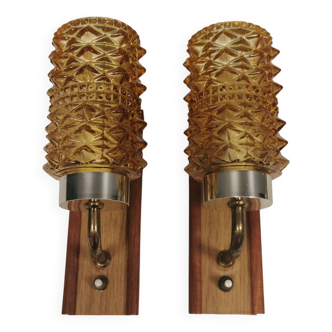 A set of wall lamps in teak wood, with amber colored glass