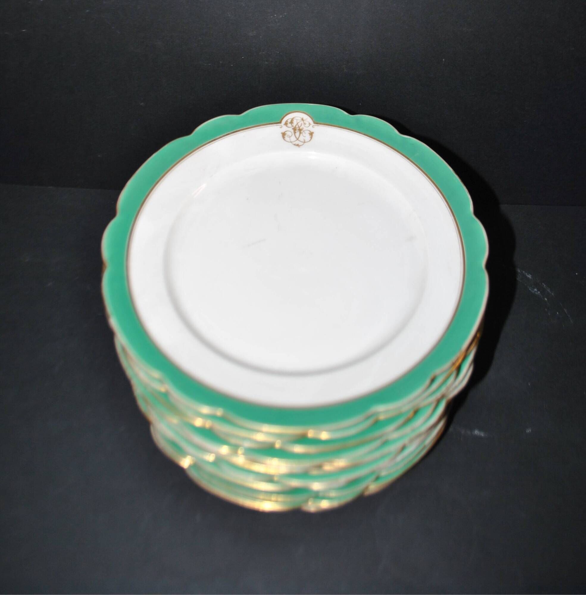Paris porcelain set of 12 flat plates with green border and gold monogram JC.