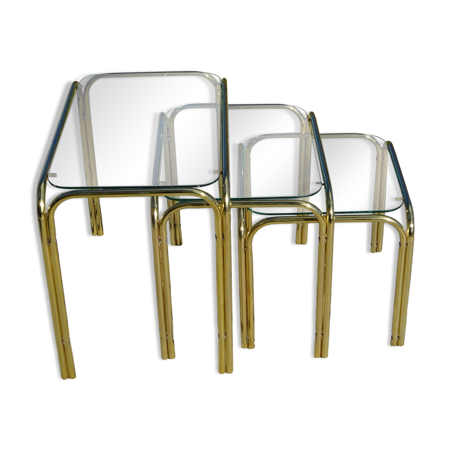 Nested tubular tables in gold metal.