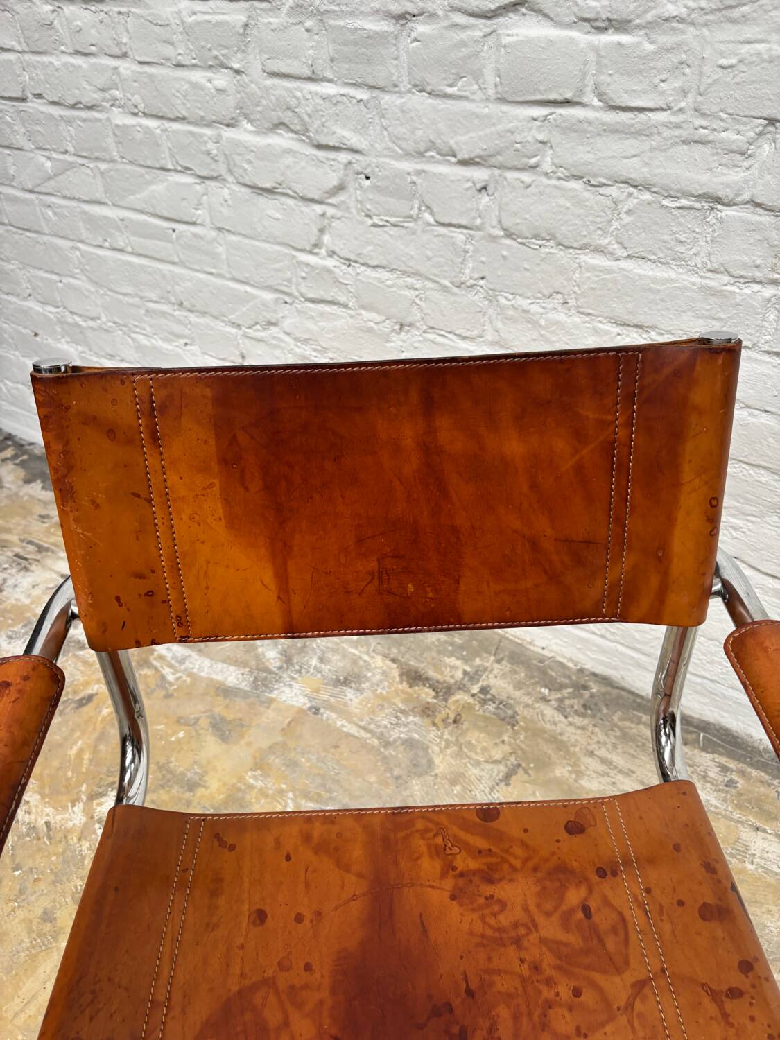 Vintage aluminum tube and tan leather armchair